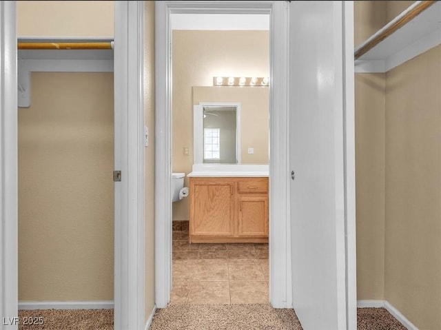 bathroom with tile patterned flooring, vanity, and toilet