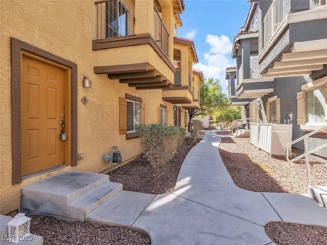 doorway to property featuring a balcony and stucco siding