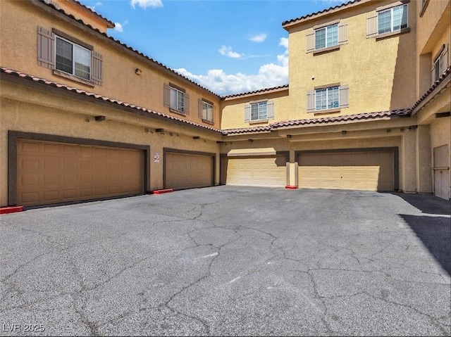 exterior space featuring a garage, driveway, and stucco siding