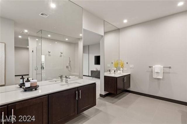 bathroom with walk in shower, vanity, and tile patterned flooring