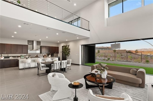 living room with light tile patterned floors and a high ceiling