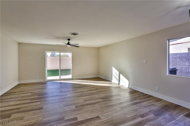 empty room with ceiling fan and hardwood / wood-style flooring