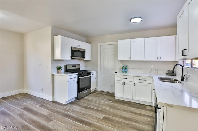 kitchen featuring sink, white cabinetry, light hardwood / wood-style flooring, and stainless steel appliances