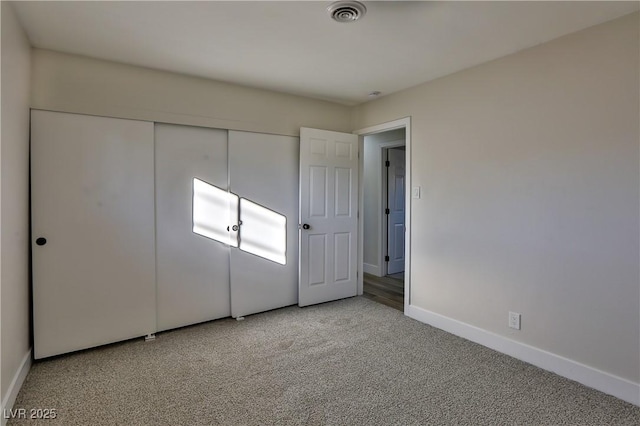 unfurnished bedroom featuring light colored carpet and a closet