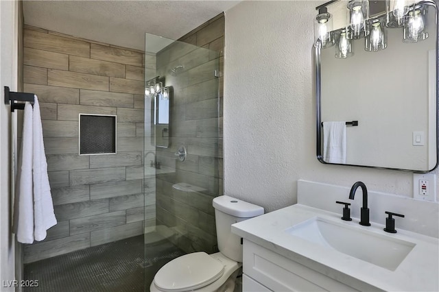 bathroom with a textured ceiling, toilet, vanity, and an enclosed shower