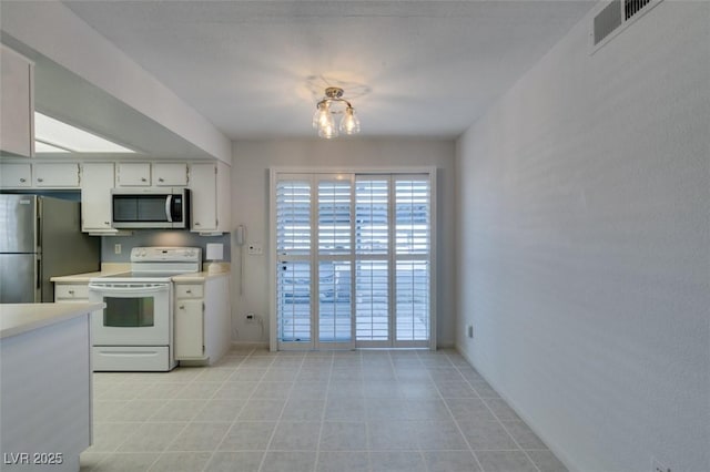 5340 Silvermist Ct Unit 103, Las Vegas, NV 89122 - kitchen with appliances with stainless steel finishes, light countertops, baseboards, white cabinets, and a chandelier