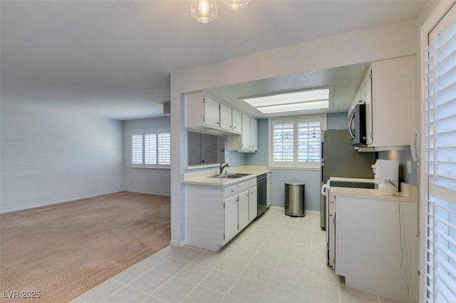 5340 Silvermist Ct Unit 103, Las Vegas, NV 89122 - kitchen featuring appliances with stainless steel finishes, light countertops, a sink, light colored carpet, and baseboards