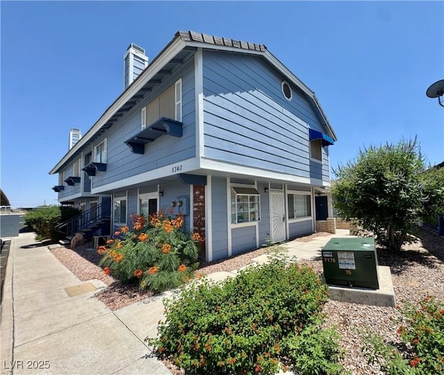 5340 Silvermist Ct Unit 103, Las Vegas, NV 89122 - view of home's exterior with a chimney and brick siding