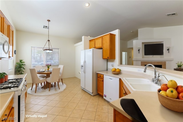 kitchen with light tile patterned floors, white appliances, a fireplace, pendant lighting, and sink