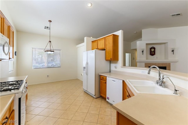 kitchen with light tile patterned flooring, decorative light fixtures, sink, and white appliances