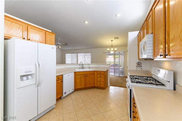 kitchen featuring kitchen peninsula, decorative light fixtures, white appliances, ceiling fan with notable chandelier, and sink