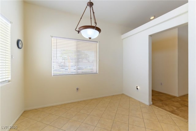 empty room with light tile patterned flooring and a healthy amount of sunlight