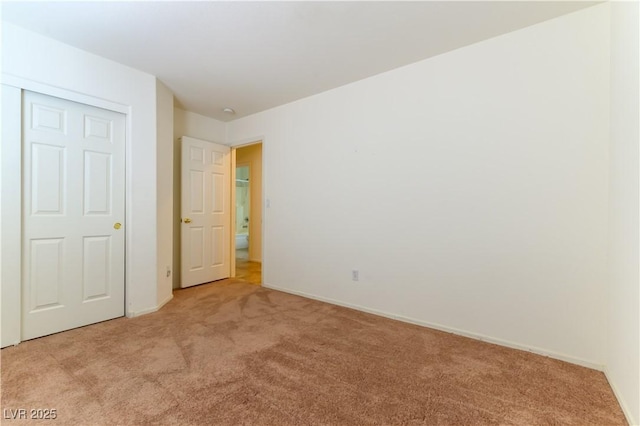 unfurnished bedroom with light carpet and a closet