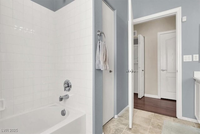 bathroom featuring shower / washtub combination, tile patterned floors, and vanity