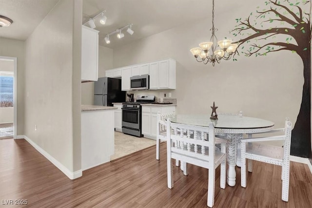 dining area featuring light wood-type flooring and a notable chandelier