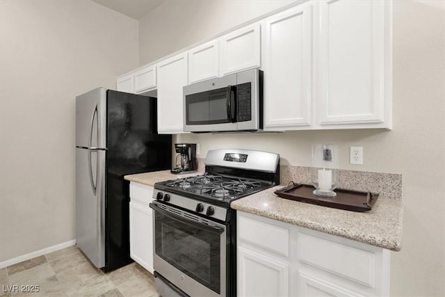 kitchen featuring light stone counters, white cabinetry, and stainless steel appliances