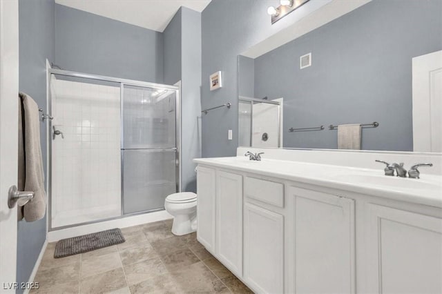 bathroom featuring toilet, a shower with door, and vanity