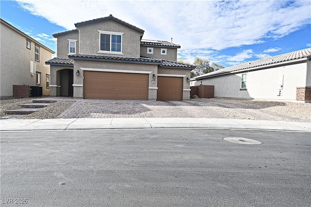 view of front of home featuring a garage and cooling unit