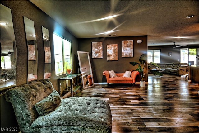 sitting room featuring ceiling fan and dark wood-type flooring