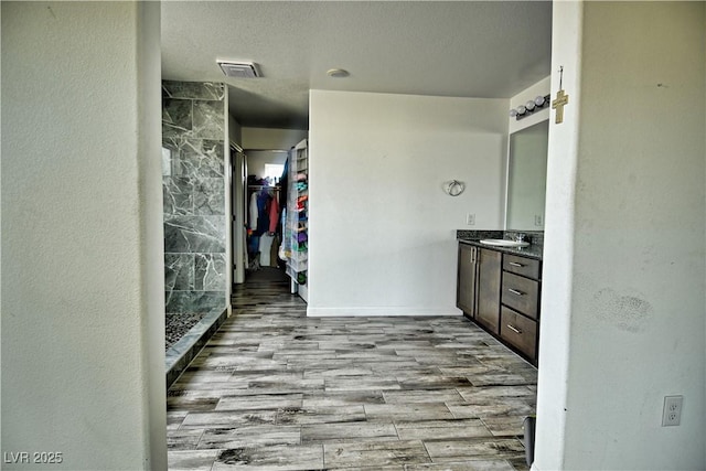 bathroom with vanity, a shower, a textured ceiling, and hardwood / wood-style floors