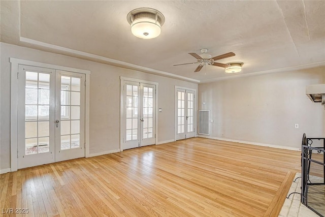 spare room with light wood-type flooring, french doors, and ceiling fan