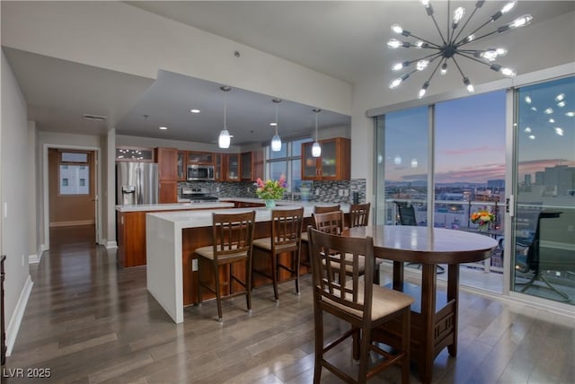 dining space with dark wood-type flooring and an inviting chandelier