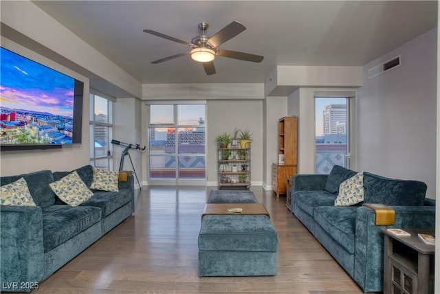 living room with ceiling fan, wood-type flooring, and a wealth of natural light