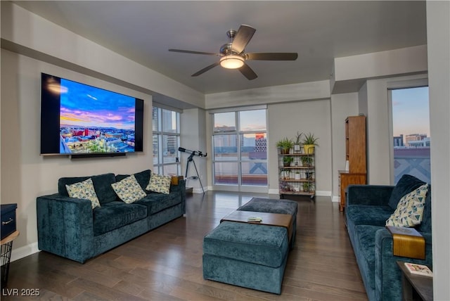 living room with dark wood-type flooring and ceiling fan