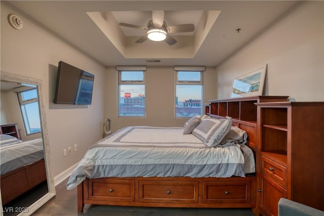 bedroom featuring ceiling fan and a tray ceiling