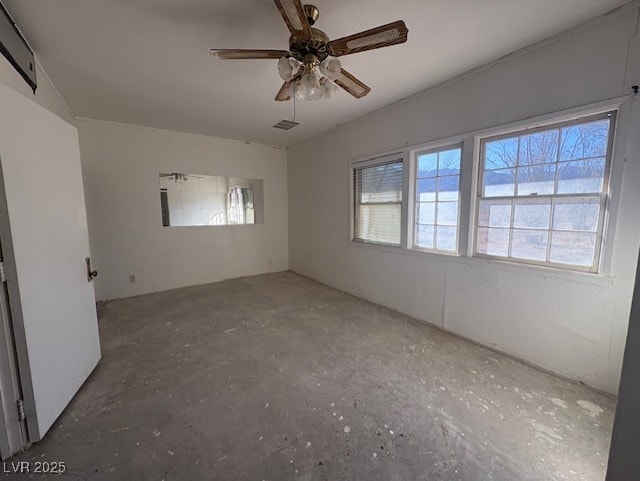 unfurnished room with ceiling fan and concrete flooring