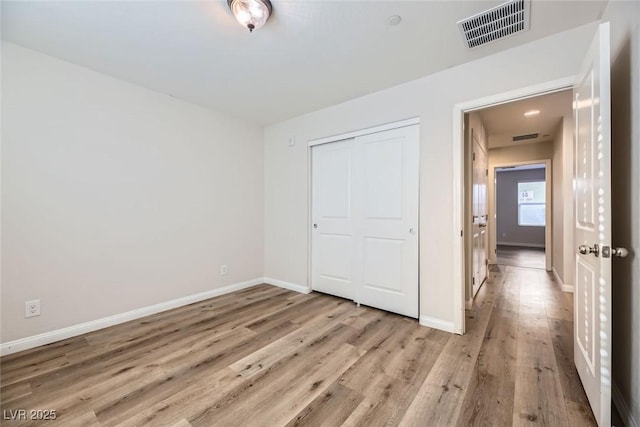 unfurnished bedroom featuring a closet and light hardwood / wood-style flooring