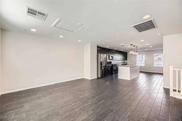 kitchen with stainless steel appliances, sink, pendant lighting, and a kitchen island with sink