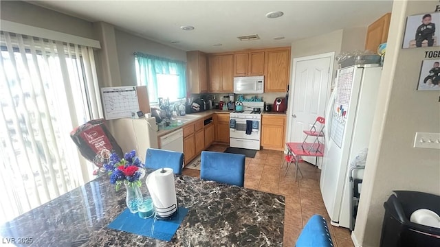 kitchen with light tile patterned floors, sink, and white appliances