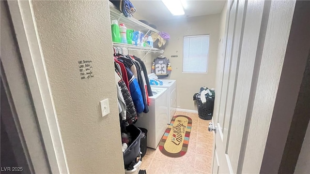 clothes washing area with light tile patterned flooring and washer and clothes dryer