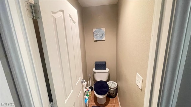 bathroom with toilet and tile patterned flooring