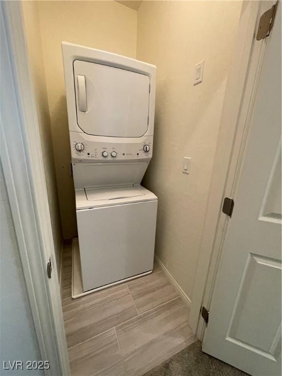 clothes washing area with stacked washer / dryer