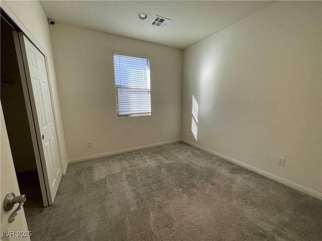 unfurnished bedroom featuring a closet and dark carpet