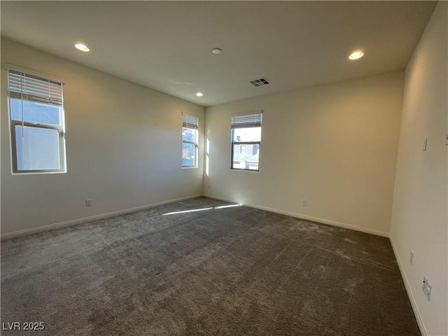 unfurnished room featuring dark colored carpet