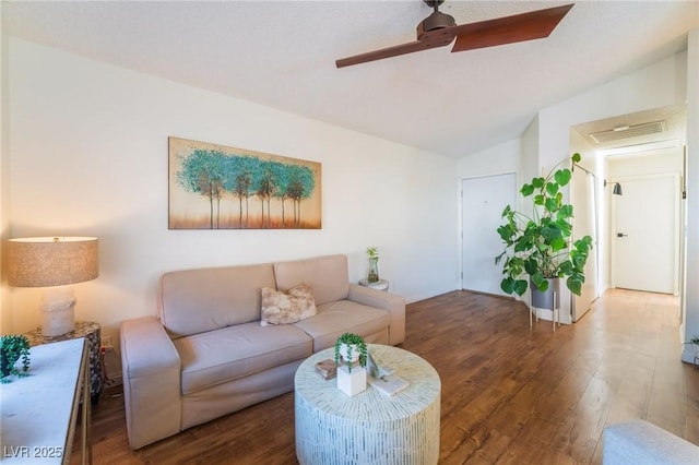 living room with ceiling fan, dark wood-type flooring, and lofted ceiling