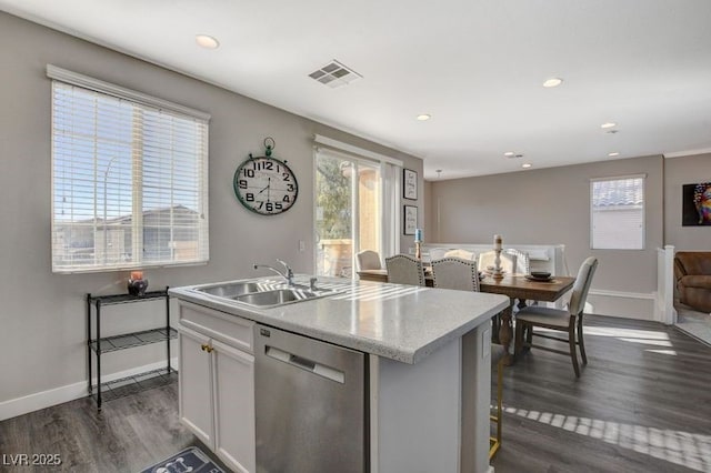 kitchen featuring stainless steel dishwasher, a kitchen island with sink, dark wood-type flooring, and white cabinetry