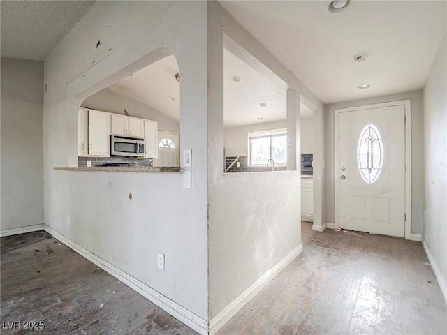 entryway featuring lofted ceiling and hardwood / wood-style floors