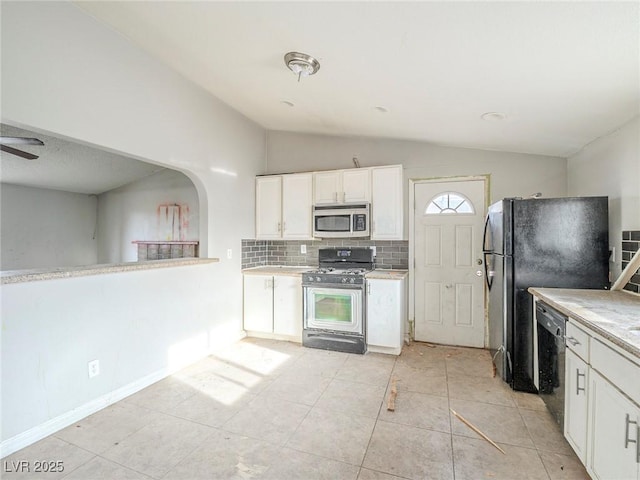 kitchen featuring white cabinets, black appliances, lofted ceiling, decorative backsplash, and light tile patterned floors