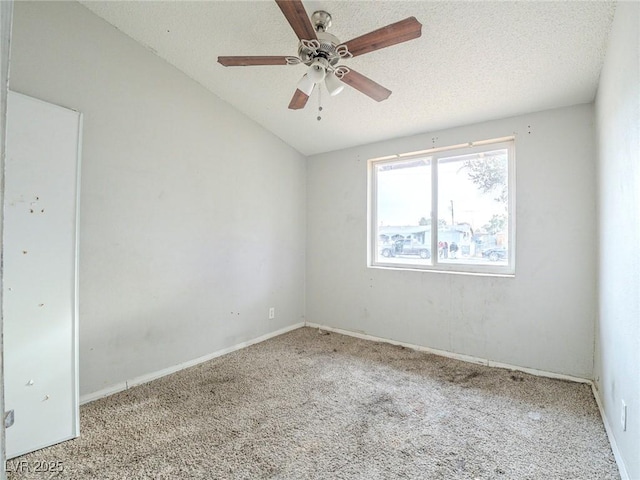 empty room featuring light carpet, ceiling fan, lofted ceiling, and a textured ceiling