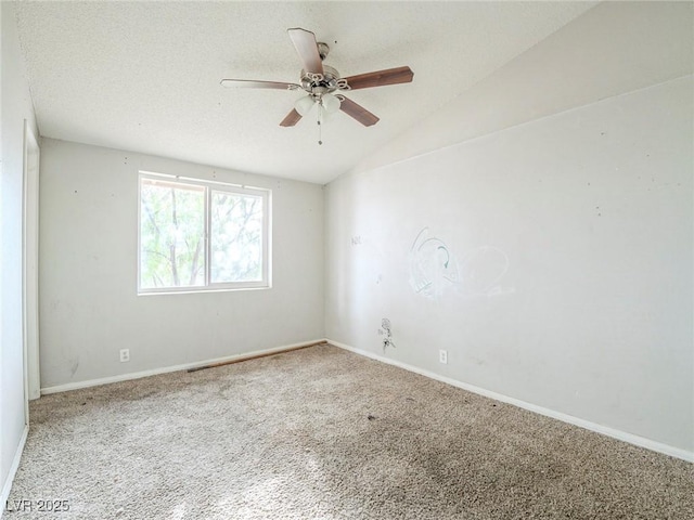 carpeted spare room with ceiling fan and vaulted ceiling