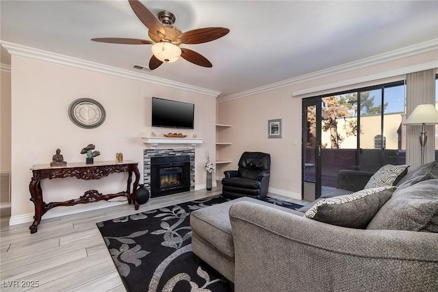 living room featuring light wood-type flooring, ceiling fan, ornamental molding, and built in features