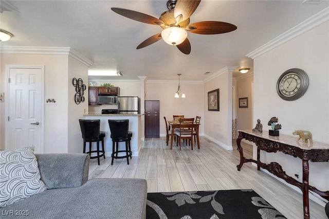 living room with ceiling fan with notable chandelier, crown molding, and light hardwood / wood-style floors