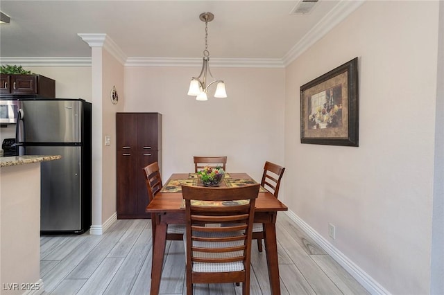 dining space featuring crown molding and a chandelier