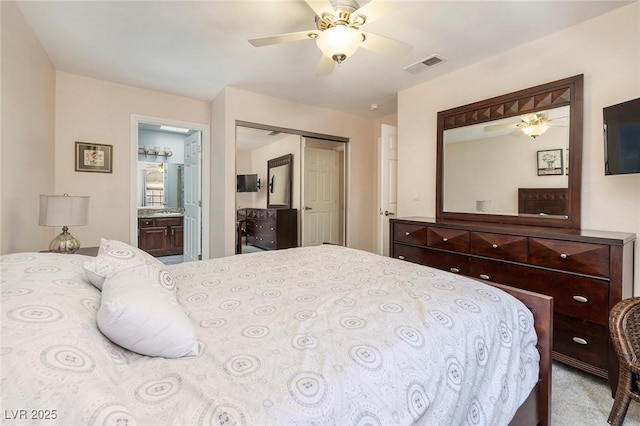 carpeted bedroom featuring ceiling fan, ensuite bathroom, and a closet