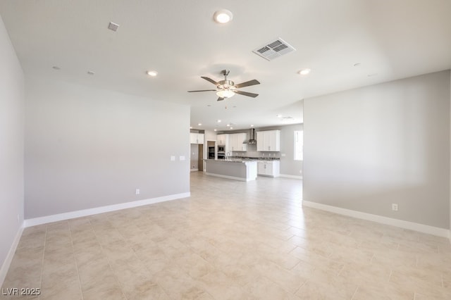 unfurnished living room featuring ceiling fan and light tile patterned floors