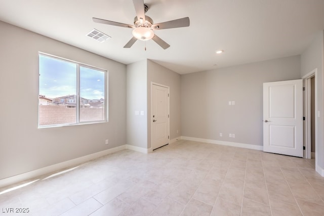 spare room with ceiling fan and light tile patterned floors